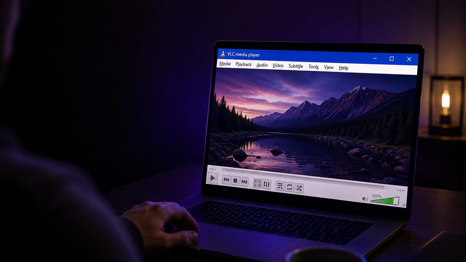 Laptop s otvorenim video plejerom na ekranu, u zamračenoj radnoj sobi