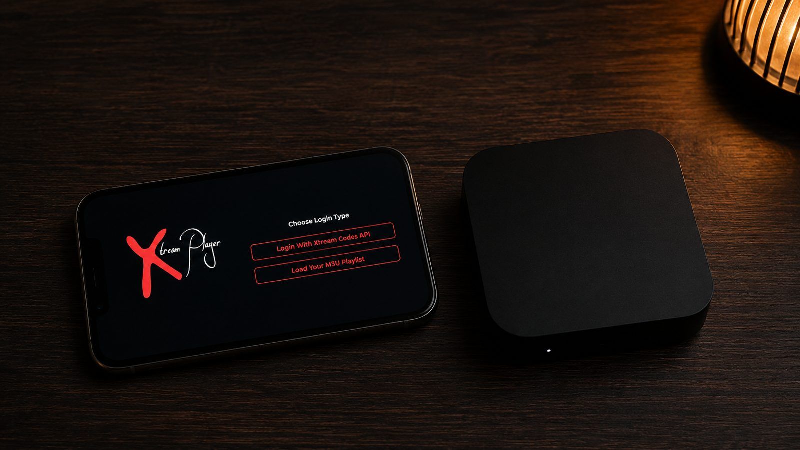 Android telefon i TV box pored televizora s IPTV plejerom u zamračenoj sobi